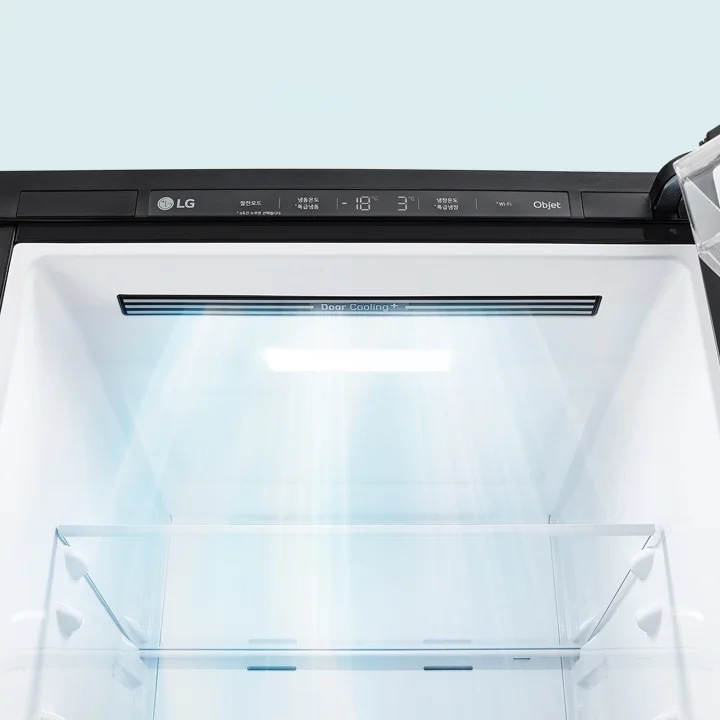 LG 로고가 있는 냉장고의 내부 모습입니다. 상단에는 Door Cooling+라는 텍스트가 보이며, 냉장고 내부에 빛이 비추고 있습니다. 조작 패널에는 냉장고 온도와 관련된 정보가 표시되어 있습니다.